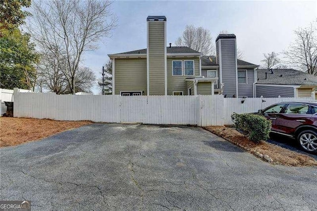 exterior space featuring a gate, a chimney, and fence