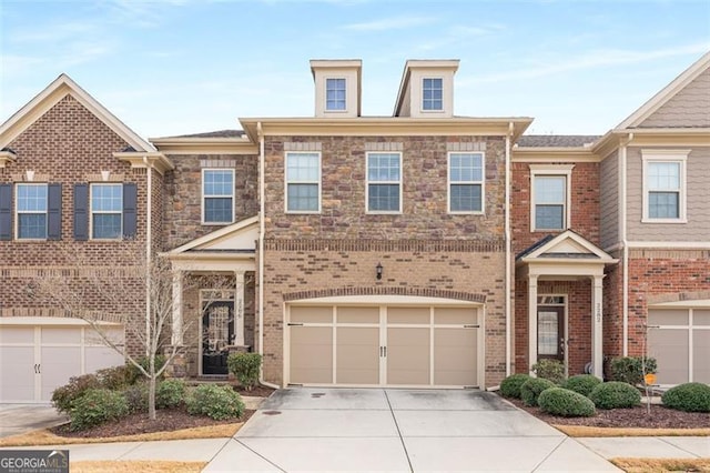 multi unit property with brick siding, a garage, and driveway