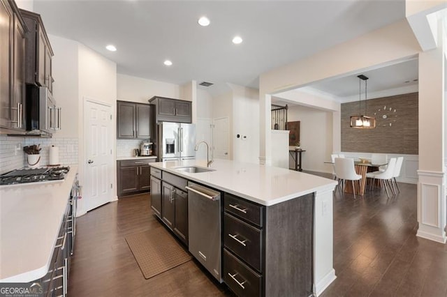 kitchen featuring dark wood-style floors, stainless steel appliances, light countertops, and a sink