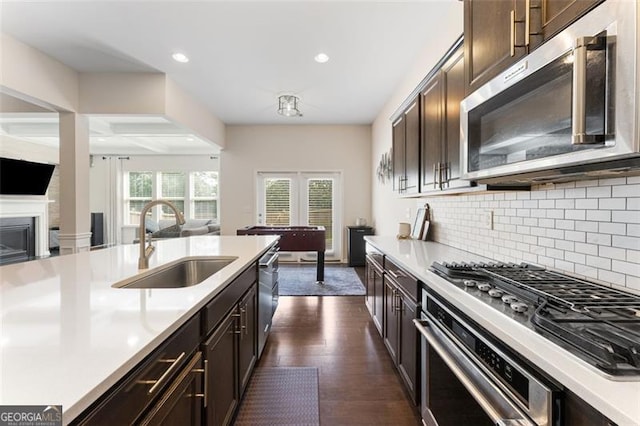 kitchen with appliances with stainless steel finishes, light countertops, and a sink