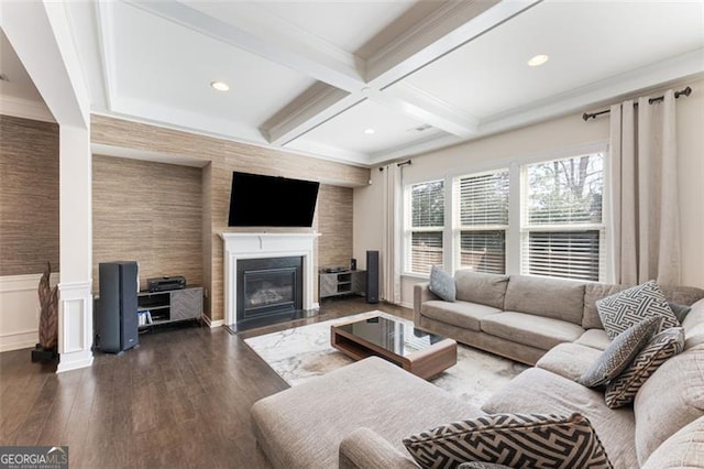 living room with beamed ceiling, a fireplace with flush hearth, wainscoting, dark wood-style floors, and coffered ceiling