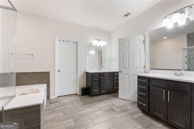 full bath featuring a sink, visible vents, a bath, and a shower stall