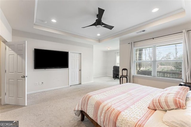 bedroom featuring baseboards, a tray ceiling, recessed lighting, light carpet, and crown molding