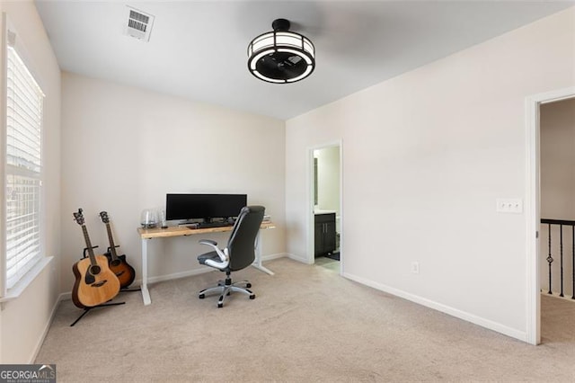 carpeted office space with baseboards and visible vents