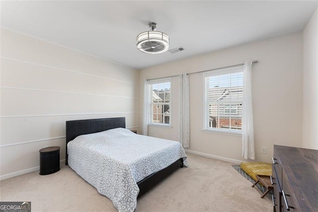 bedroom featuring visible vents, light colored carpet, and baseboards