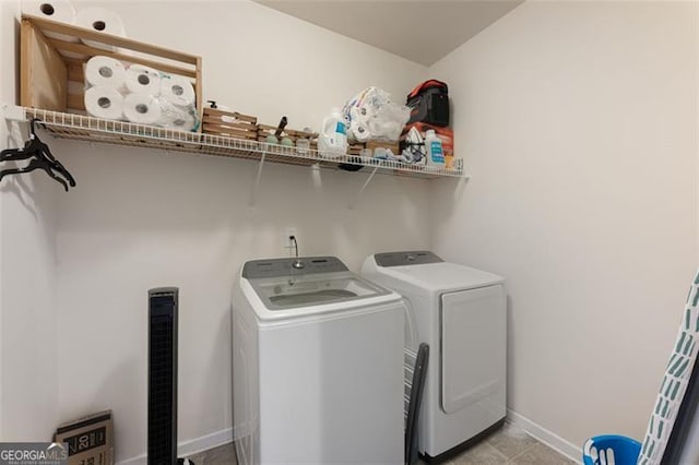 washroom featuring laundry area, baseboards, and washing machine and clothes dryer