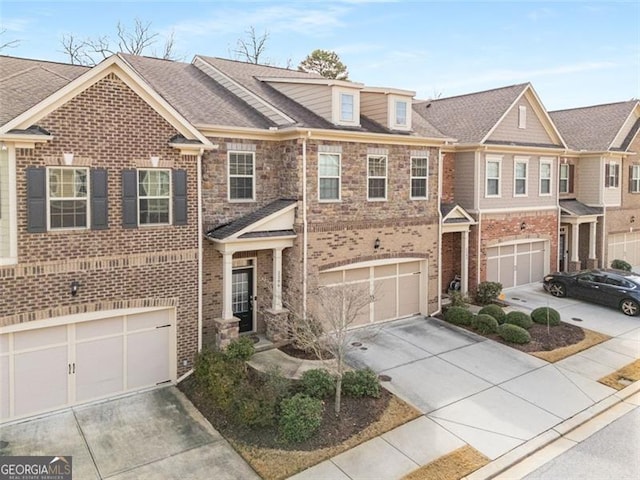 view of property featuring a garage, brick siding, and driveway