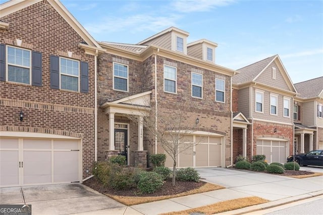 view of property featuring an attached garage, brick siding, and driveway