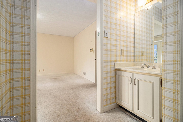 bathroom featuring wallpapered walls and vanity
