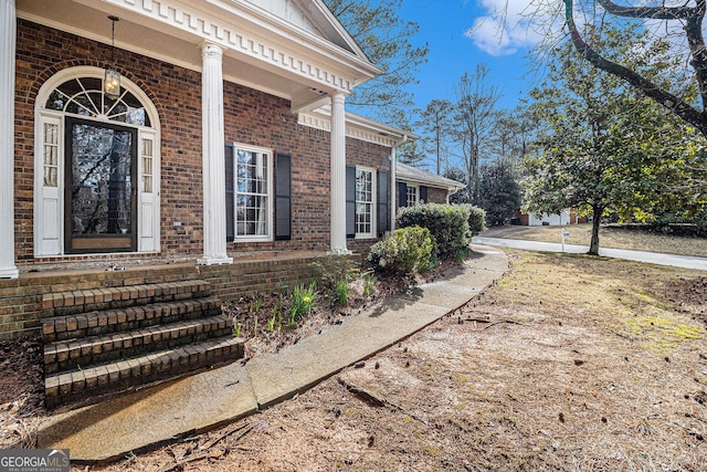 entrance to property featuring brick siding