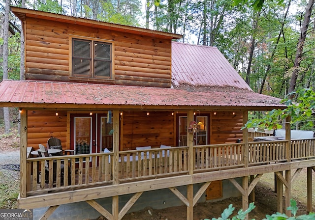 back of property with metal roof and faux log siding