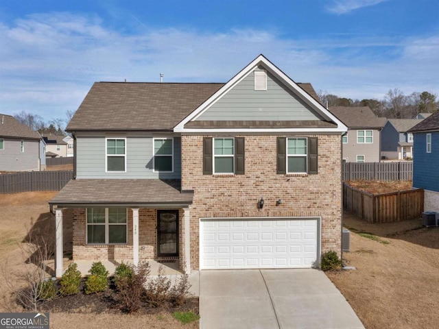 traditional-style home featuring brick siding, concrete driveway, and fence