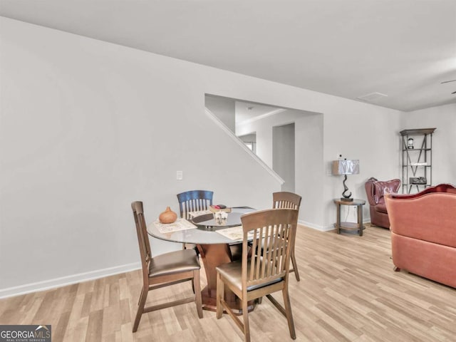 dining space featuring light wood-style flooring and baseboards