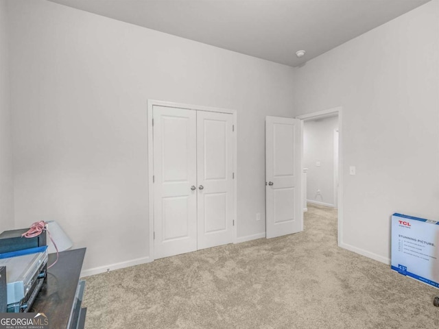 carpeted bedroom featuring a closet and baseboards