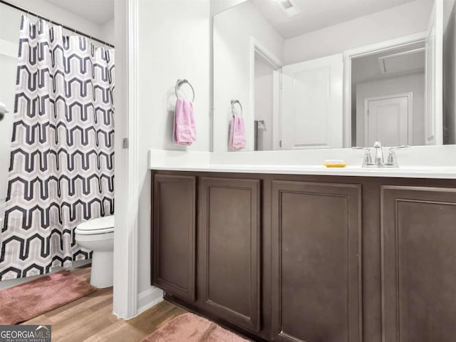 full bath with toilet, vanity, a shower with curtain, and wood finished floors