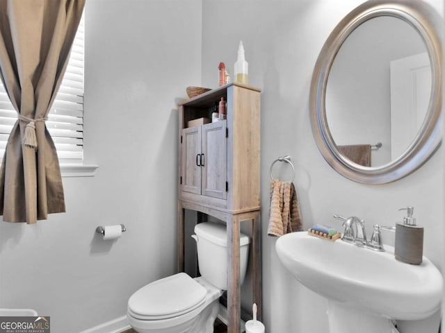 bathroom featuring a sink, baseboards, and toilet