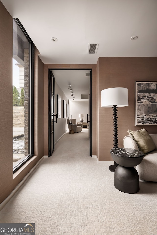 corridor featuring visible vents, baseboards, and carpet flooring