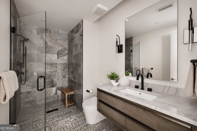 bathroom featuring tile patterned floors, visible vents, toilet, a shower stall, and vanity