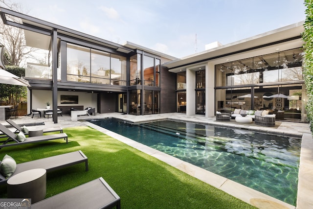 pool featuring an outdoor living space and a patio area