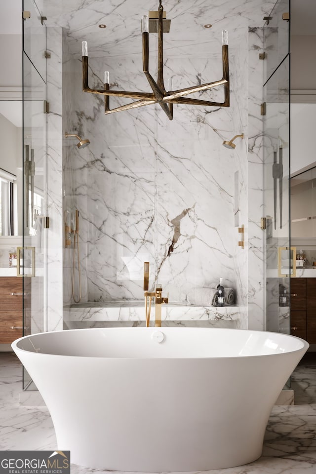 bathroom with a marble finish shower, marble finish floor, stone wall, and vanity