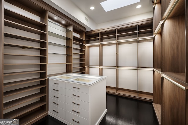 walk in closet with dark wood-style floors and a skylight