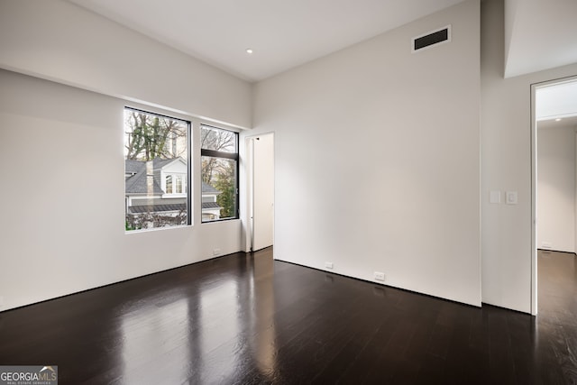 unfurnished room with wood finished floors and visible vents