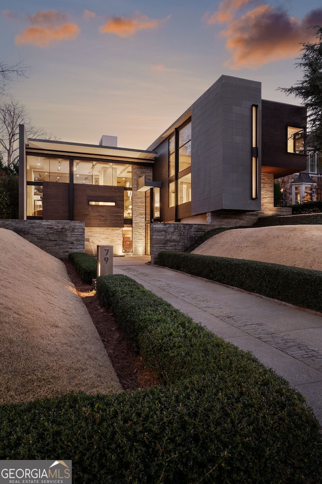 contemporary home with stone siding and driveway