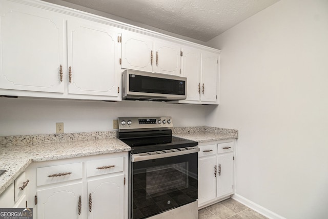 kitchen featuring white cabinetry, stainless steel appliances, light countertops, and a textured ceiling