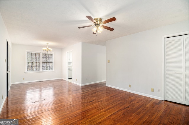 unfurnished living room featuring ceiling fan with notable chandelier, a textured ceiling, baseboards, and wood-type flooring