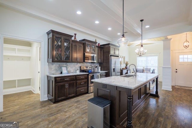 kitchen featuring dark wood-type flooring, a sink, stainless steel appliances, dark brown cabinetry, and decorative backsplash