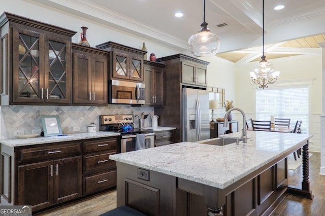 kitchen featuring dark wood-type flooring, dark brown cabinetry, decorative backsplash, stainless steel appliances, and a sink