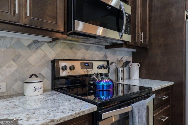 kitchen featuring dark brown cabinets, tasteful backsplash, and appliances with stainless steel finishes