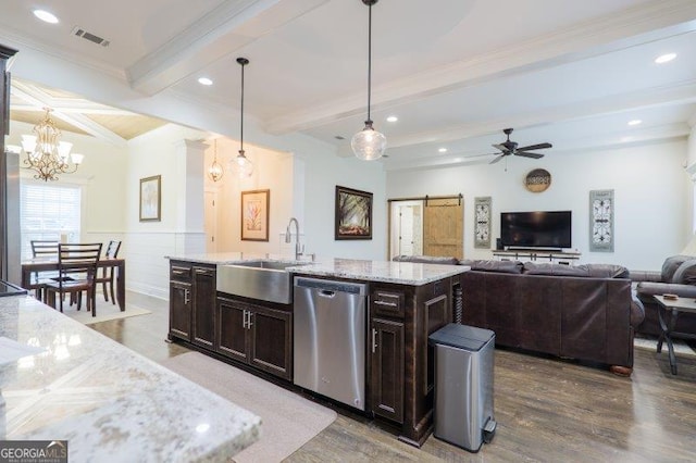 kitchen with open floor plan, beamed ceiling, a barn door, stainless steel dishwasher, and a sink