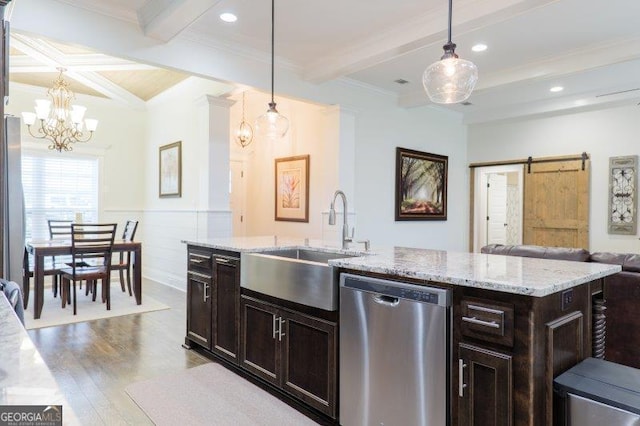 kitchen with beam ceiling, a sink, a barn door, light wood finished floors, and dishwasher