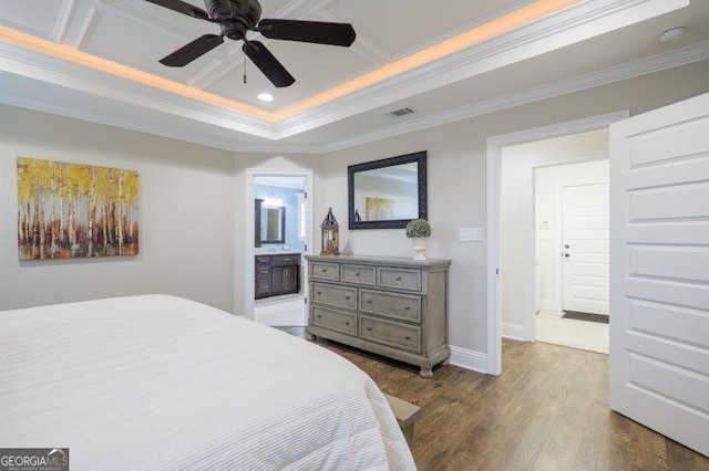 bedroom with visible vents, baseboards, dark wood finished floors, ensuite bath, and crown molding