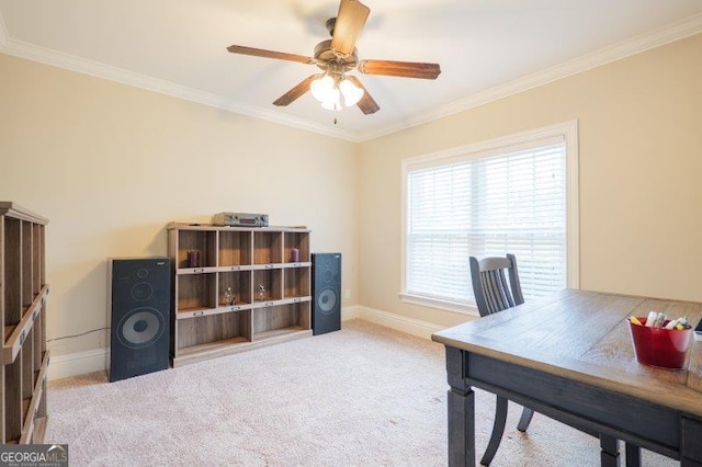 office area featuring light carpet, a ceiling fan, baseboards, and ornamental molding