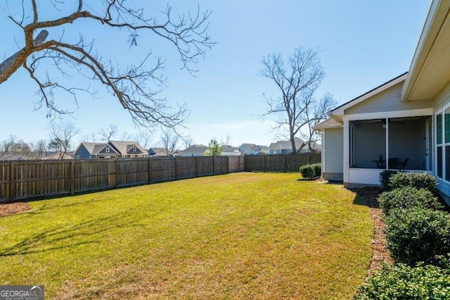 view of yard featuring a fenced backyard and a sunroom