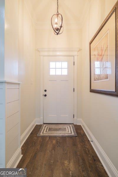 entryway featuring dark wood finished floors, crown molding, and baseboards