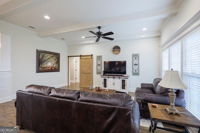 living room with beamed ceiling, baseboards, a barn door, and ornamental molding