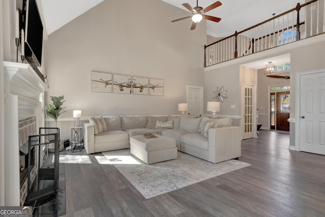 living area featuring ceiling fan, french doors, wood finished floors, and a fireplace