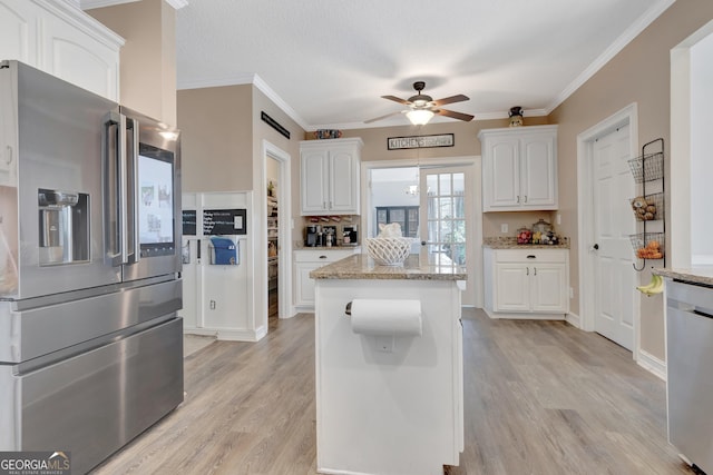 kitchen with light stone countertops, appliances with stainless steel finishes, white cabinets, and light wood finished floors