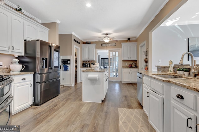 kitchen with white cabinetry, light wood finished floors, appliances with stainless steel finishes, and a sink