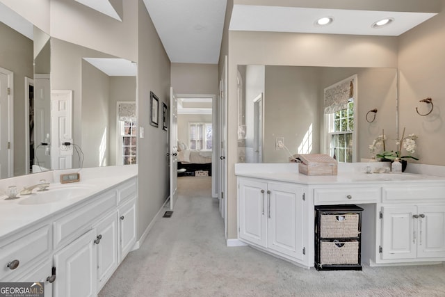 full bath with a wealth of natural light, connected bathroom, two vanities, and a sink