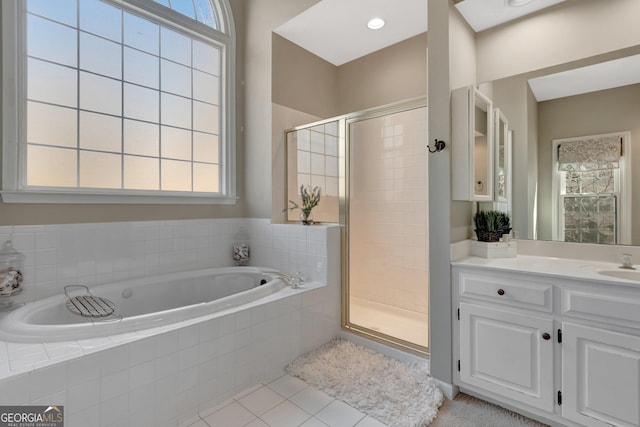 full bathroom featuring tile patterned floors, plenty of natural light, a garden tub, and a stall shower