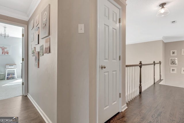 hallway with crown molding, baseboards, dark wood-type flooring, and visible vents