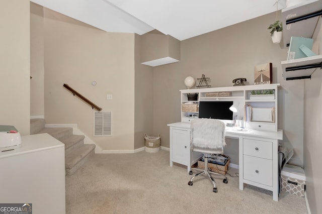 office with baseboards, visible vents, and light carpet