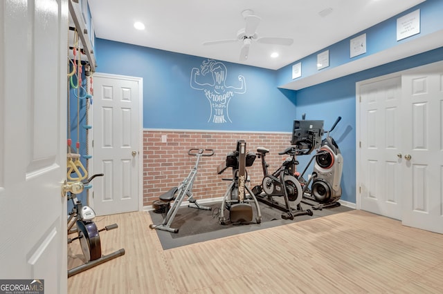 exercise room with ceiling fan, wood finished floors, brick wall, and recessed lighting