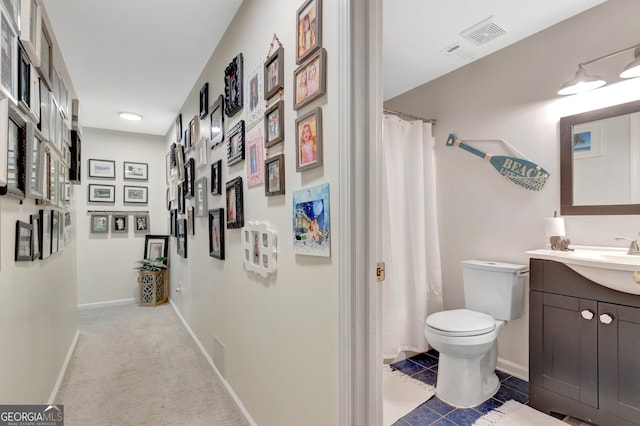 full bath with visible vents, toilet, a shower with shower curtain, baseboards, and vanity