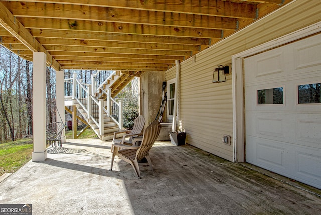 view of patio / terrace featuring stairway and a garage