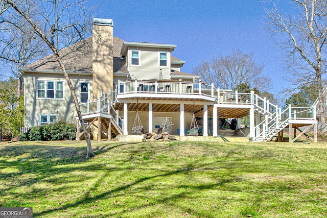 back of property featuring stairway, a yard, a chimney, and a wooden deck